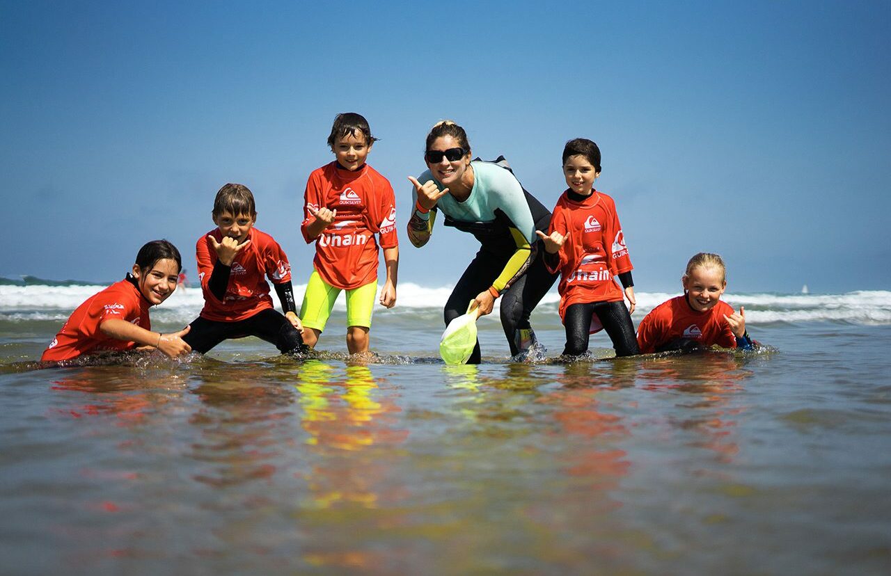 Groupe de débutants participant à un cours de surf sur une plage d'Anglet avec un moniteur